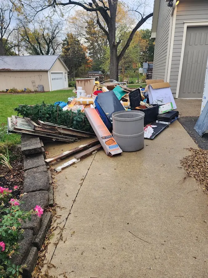 Dumpster being loaded with debris for 12 Yard Dumpster Rental in Bemidji